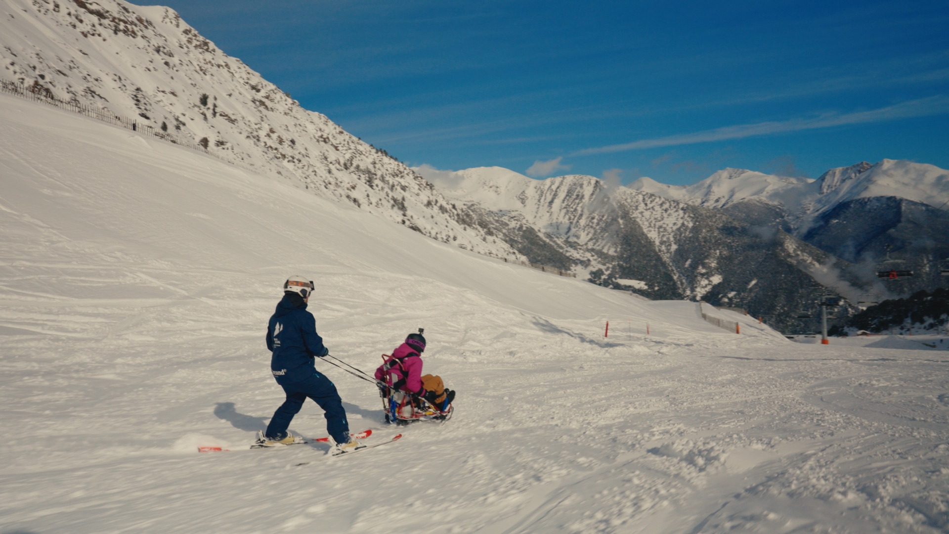 IPF member on sled is led down the mountain by a guide